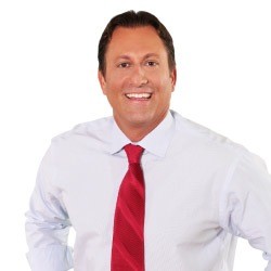 Kevin Rowe wearing a white shirt and red tie.