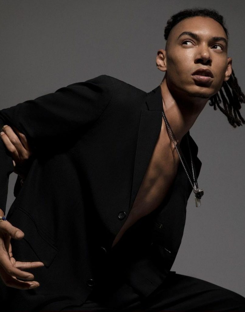 Grace Jones son Paulo Goude wearing a black coat.