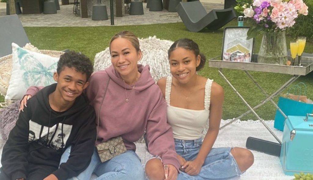 Dwayne Carter III sitting on the ground with his mother and half sister.