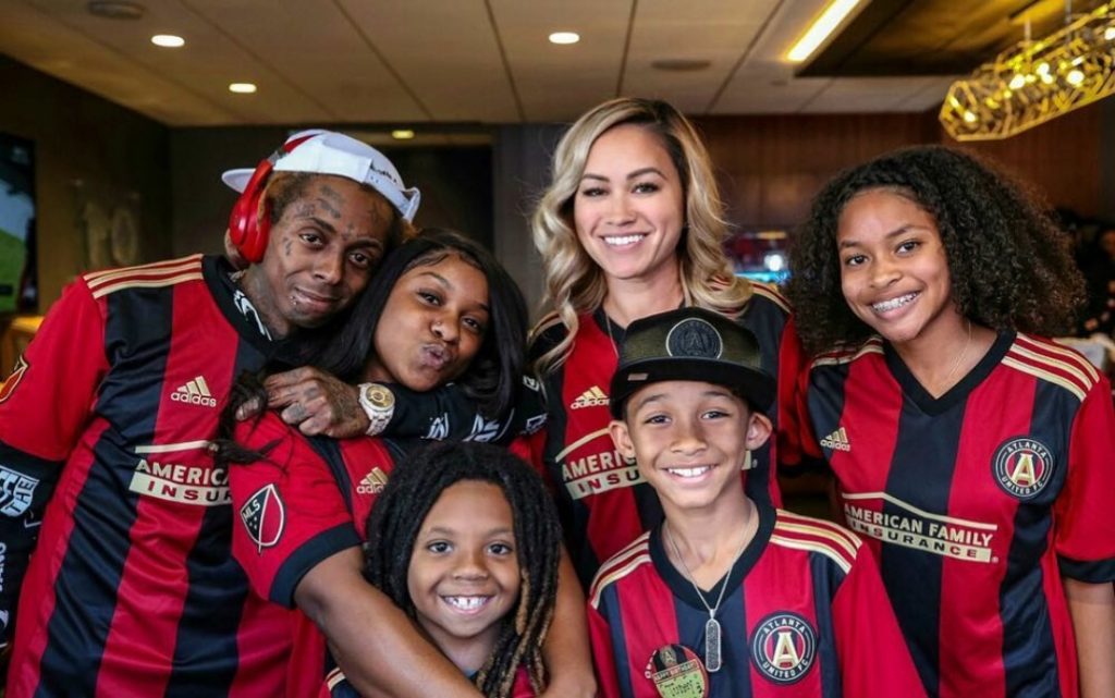 Dwayne Carte III posing with his full family wearing red color t-shirt. 