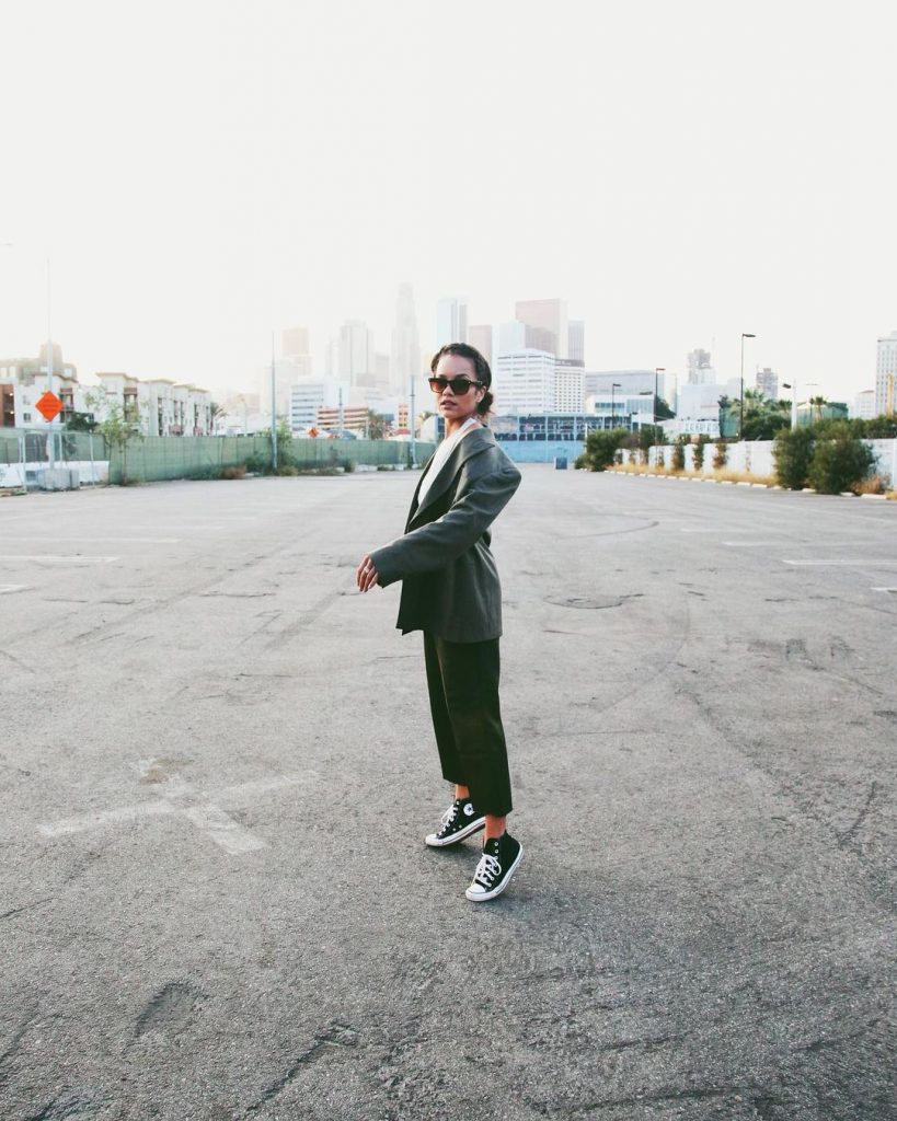 Alyssa Wearing Sneakers and sunglasses with coat and trouser.