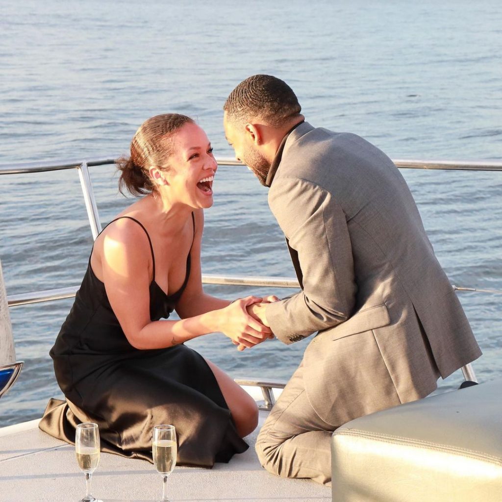 Alyssa and Phillip celebrating their engagement on a ship.