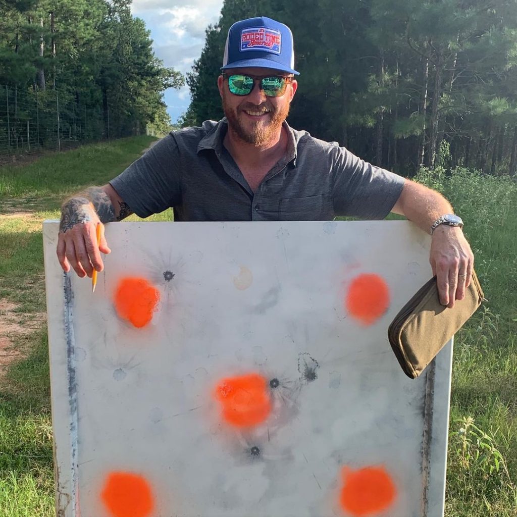 Cody Johnson wearing blue cap standing near a white board