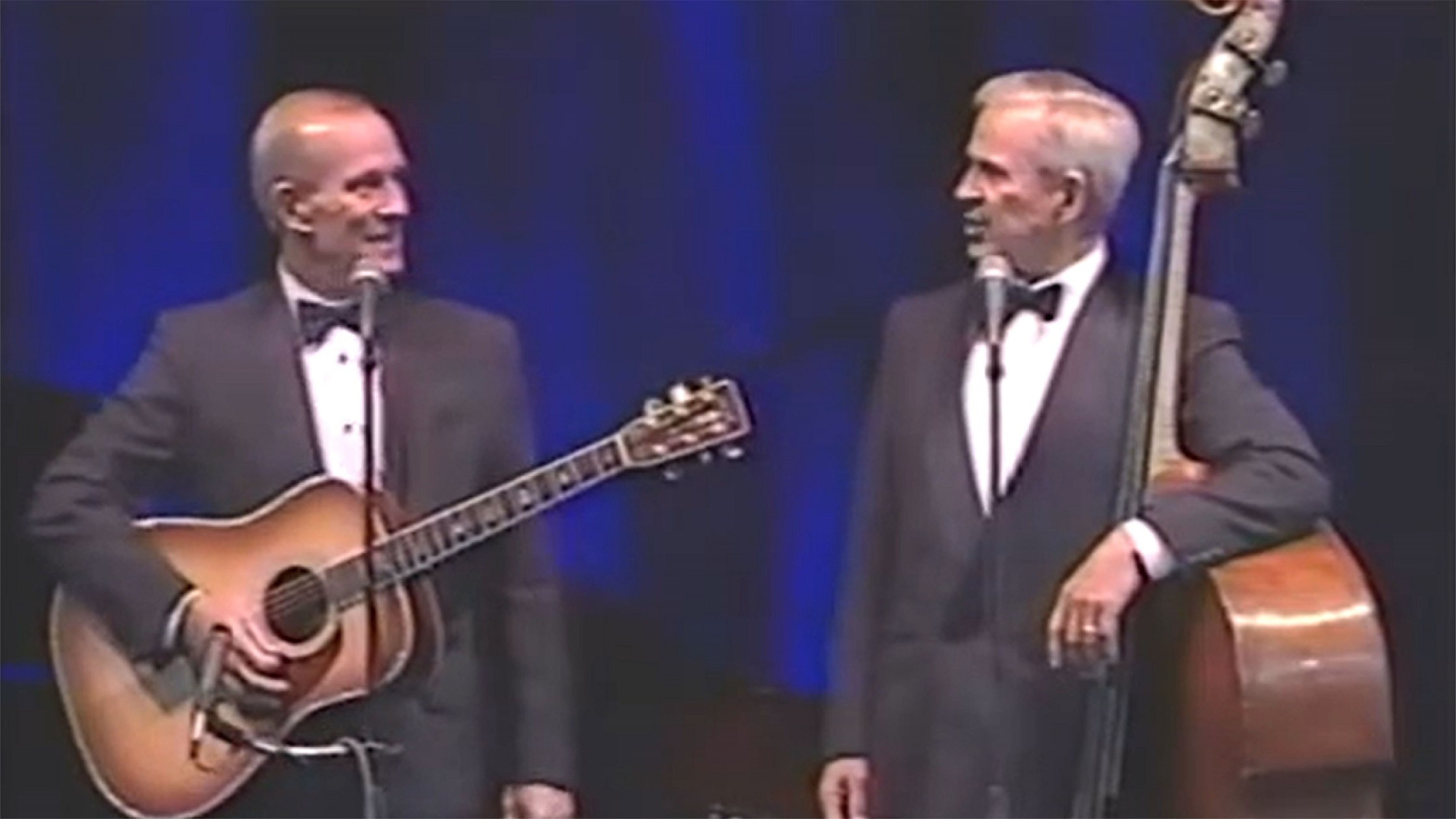 Smothers Brothers playing guita and performing on stage