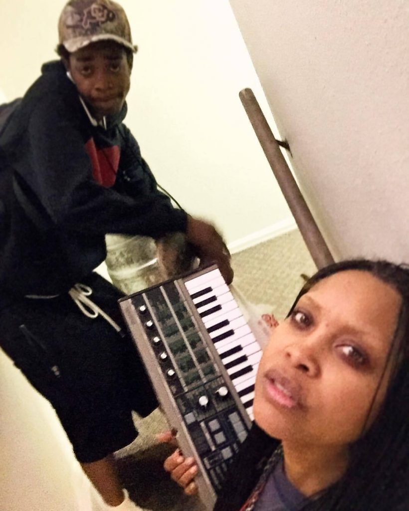 Erykah with her son Seven teaching him piano