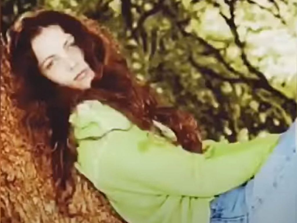 Erin wearing a green top and blue jeans.