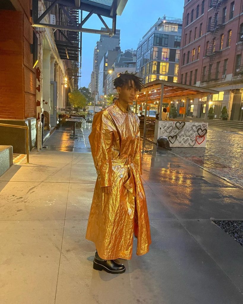 Jaden wearing a golden rob posing on the street.