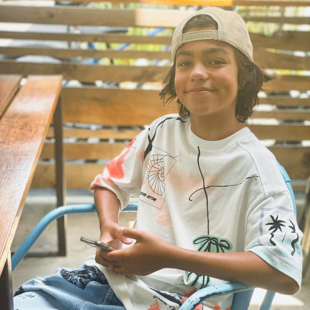 Malachi wearing white tee and cap.