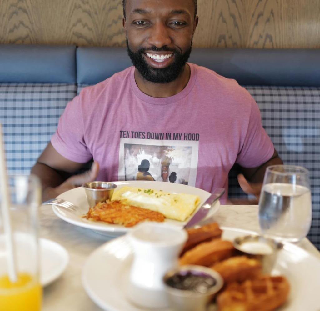 Jamie wearing a purple shirt and heating his meal.