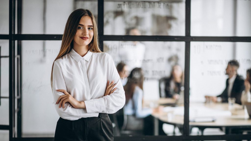 A woman standing confidently in a workplace.