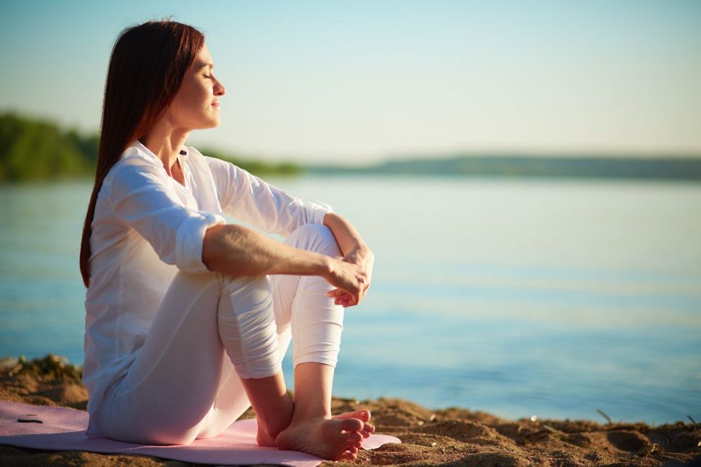 A girl sitting alone on a river side.