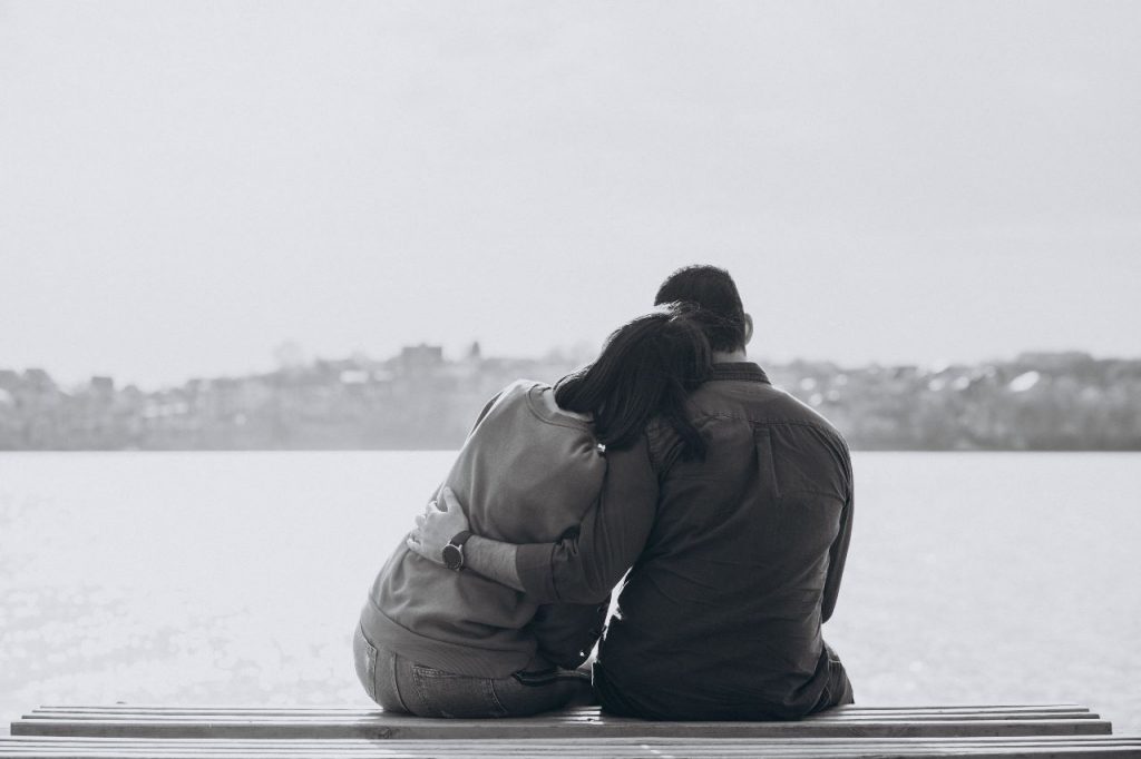 A girl sitting and laid her head on a man's shoulder.