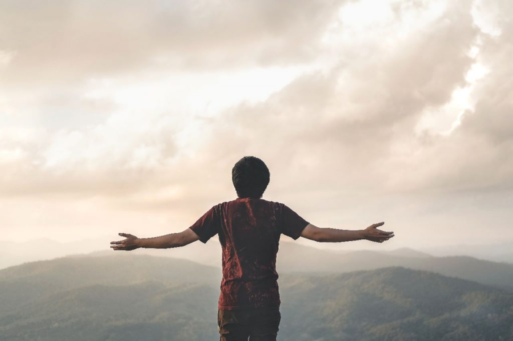 A guy enjoying the view from the mountains.