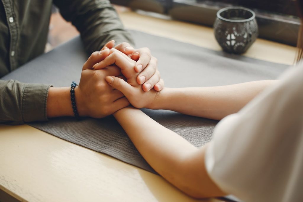 two people holding hands together.