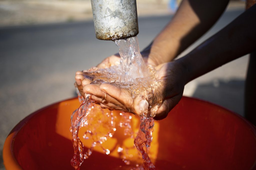 woman pouring water in the bucket.