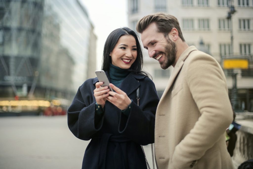 A man seeing on the phone of a woman.