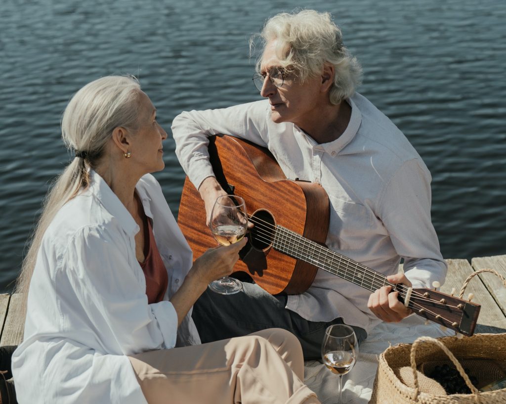 An old man playing guitar for his wife. 