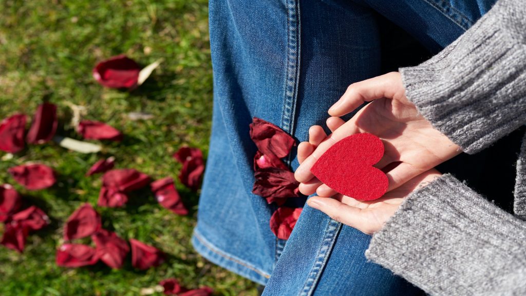 A girl holding a paper heart.