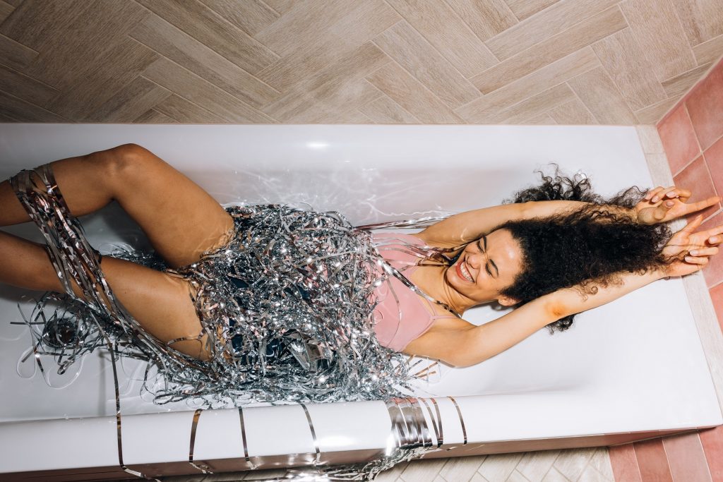 A girl laying carefree in the bathtub.