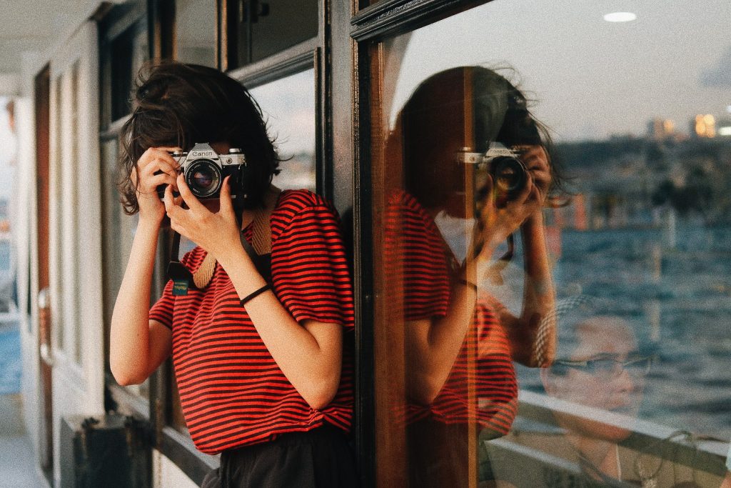 A girl clicking pictures from her camera.