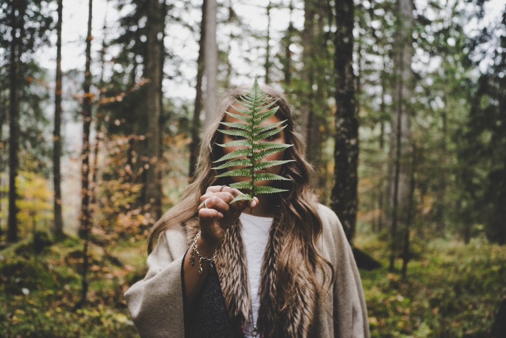 A woman holding a green leaf in her hand.