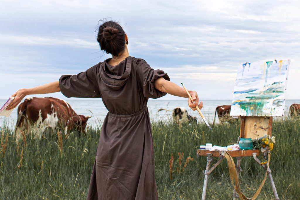 A girl enjoying doing painting at a serene place.
