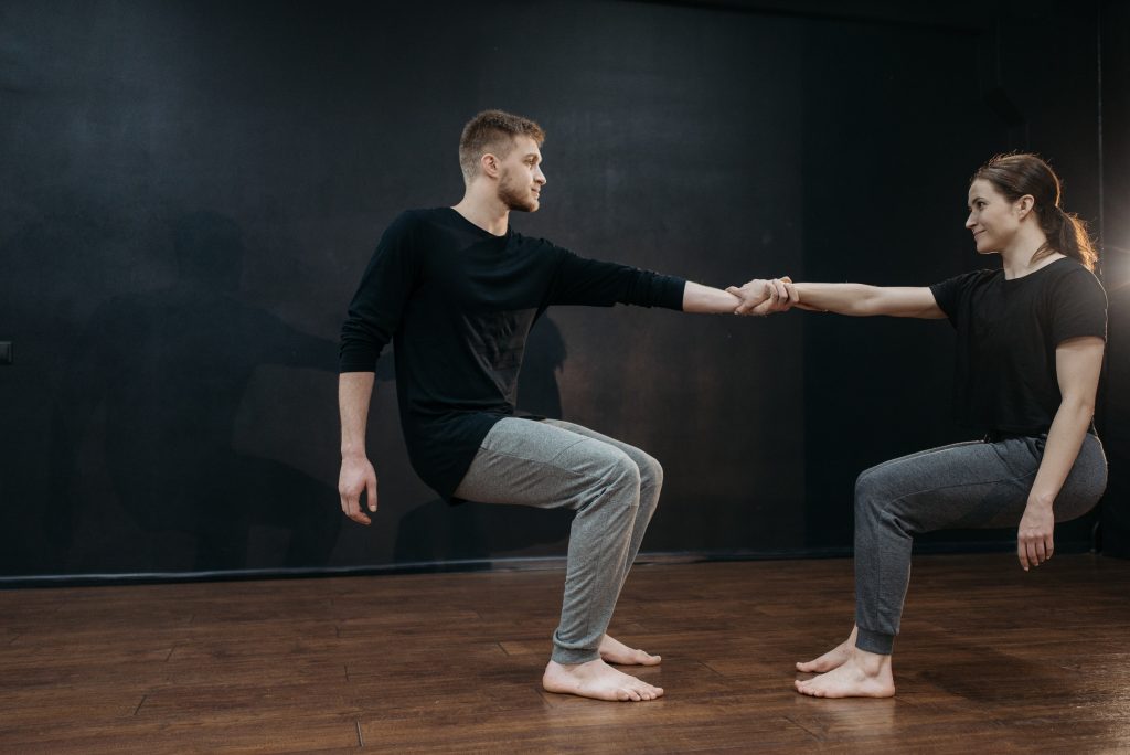 A man and woman balancing each other holding hands.