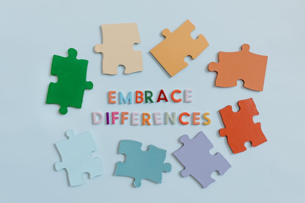 Embrace differences written on a blue background with colorful tiles.