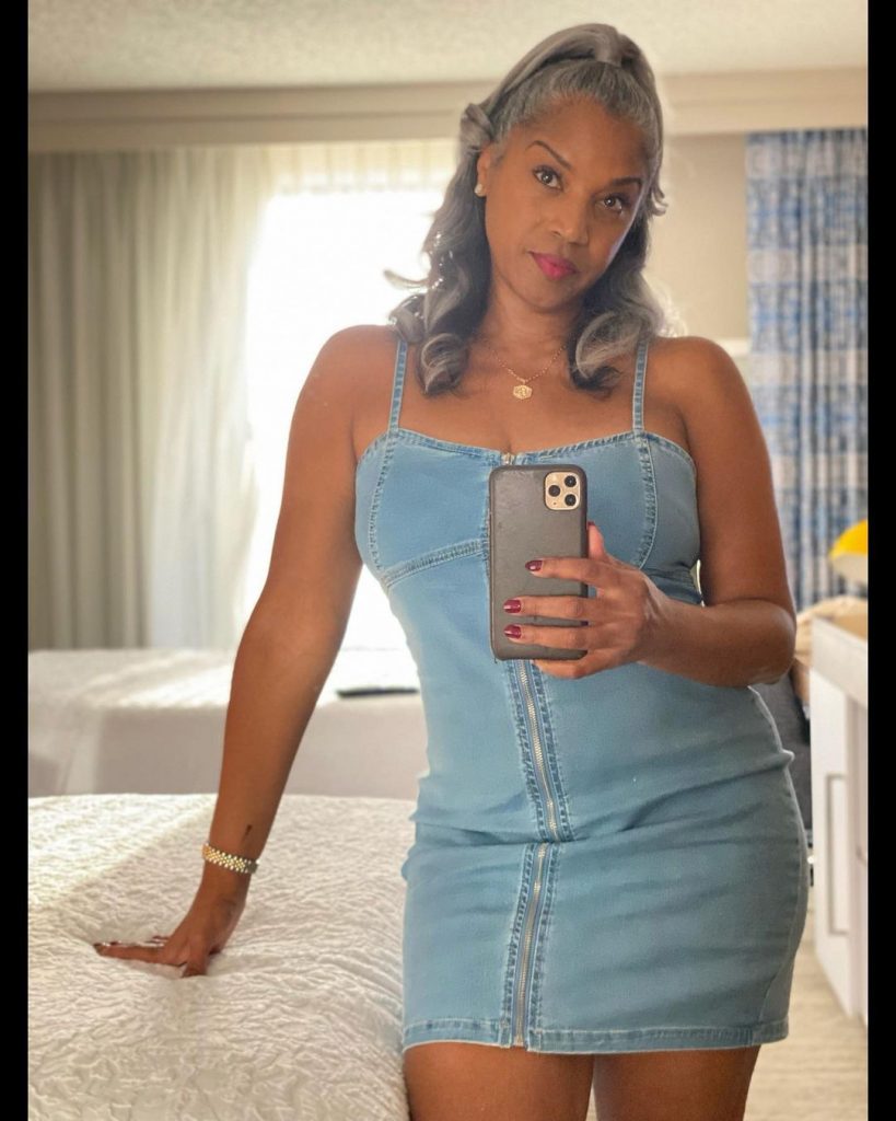 Rolonda taking a mirror selfie wearing denim dress.