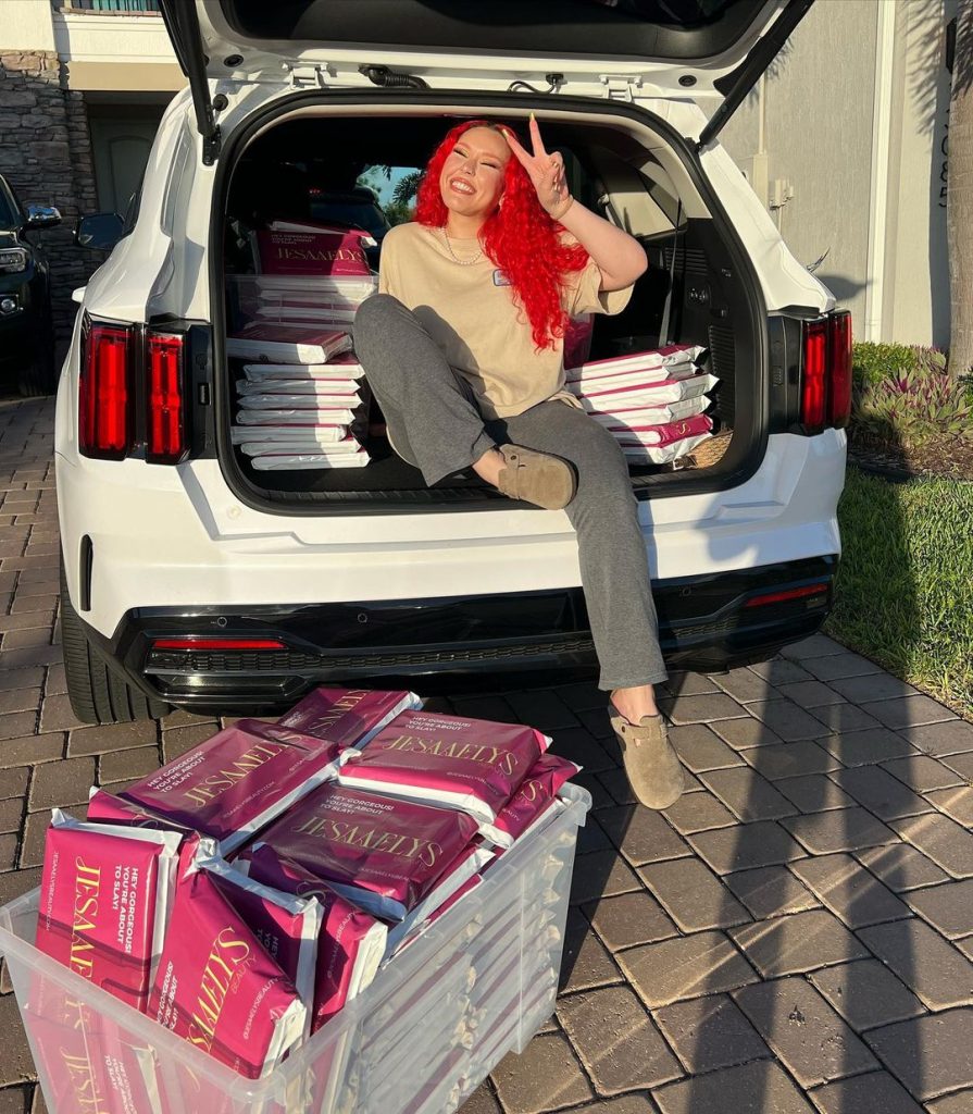 Jesaaelys sitting in the backseat of car with her brand's products.