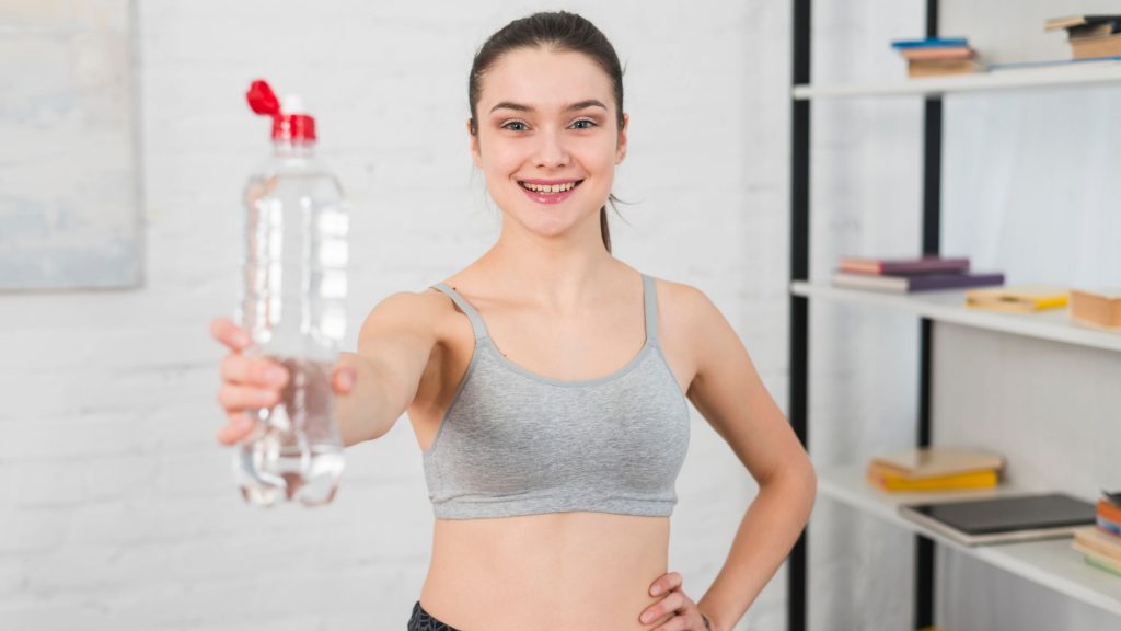 A girl holding a bottle of water in her hand.