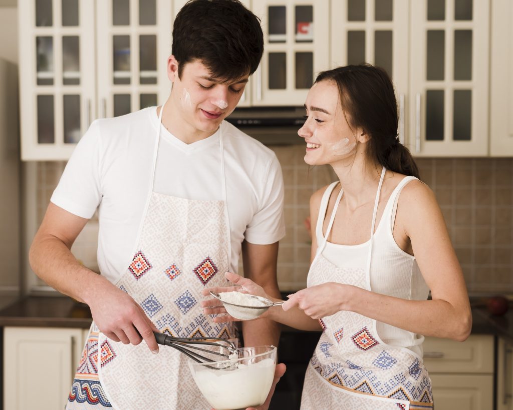 beautiful-young-woman-boyfriend-together preparing batter for baking.